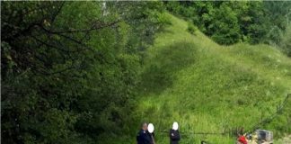 O familie a rămas cu mașina blocată în noroi pe marginea unei ape